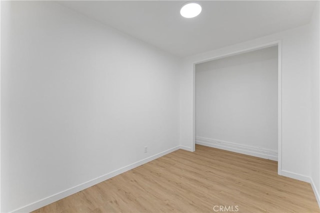 spare room with light wood-style floors and baseboards