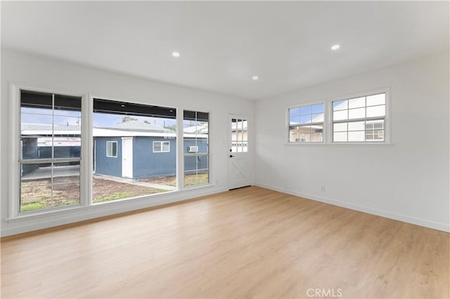 unfurnished room featuring recessed lighting, baseboards, and wood finished floors