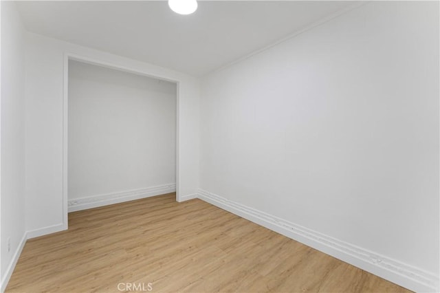 spare room featuring light wood-style flooring and baseboards