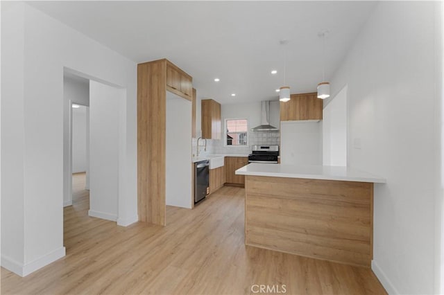 kitchen featuring light wood-style flooring, wall chimney range hood, stainless steel appliances, light countertops, and decorative backsplash