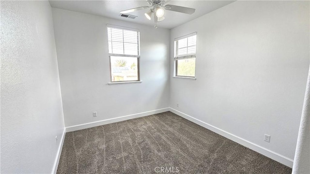 unfurnished room featuring a ceiling fan, baseboards, visible vents, and dark colored carpet