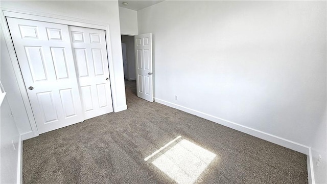 unfurnished bedroom featuring a closet, baseboards, and carpet floors