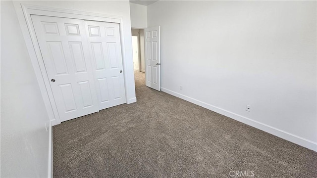 unfurnished bedroom featuring baseboards, carpet floors, and a closet