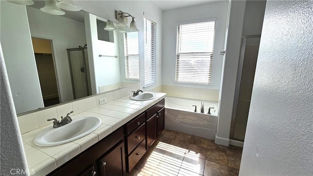 full bathroom featuring a sink, a garden tub, a stall shower, and double vanity