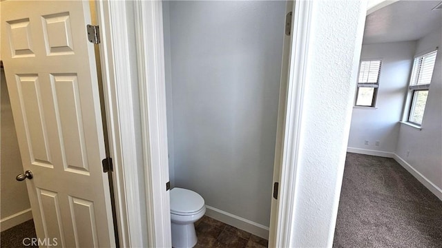 bathroom featuring toilet and baseboards