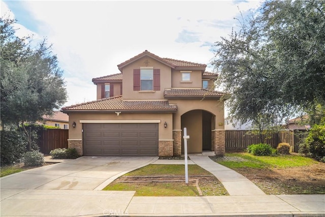 mediterranean / spanish-style house featuring fence, brick siding, driveway, and stucco siding