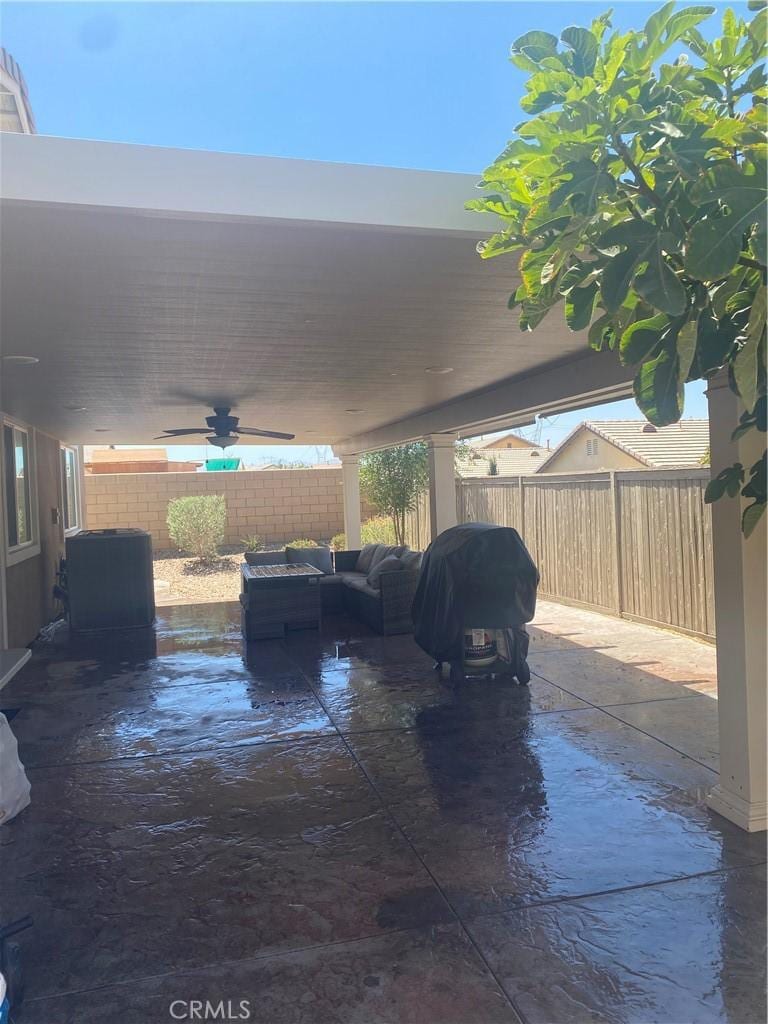 view of patio with area for grilling, a fenced backyard, and a ceiling fan