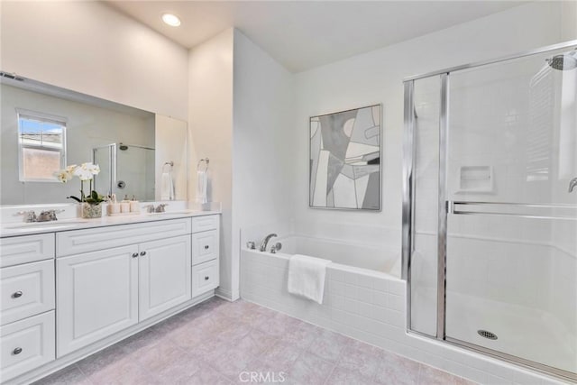 full bathroom with double vanity, a shower stall, a garden tub, and a sink