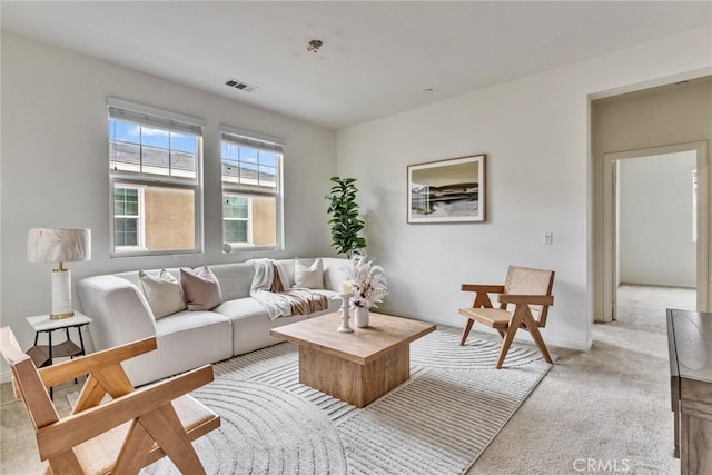 living room with light carpet, visible vents, and baseboards