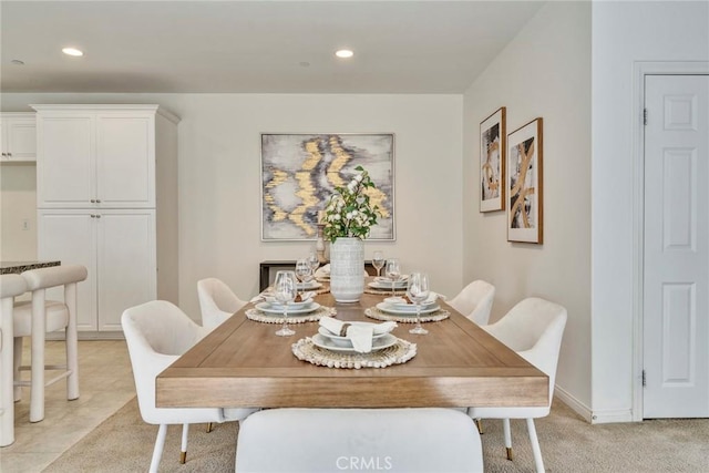 dining space with recessed lighting, light colored carpet, and baseboards