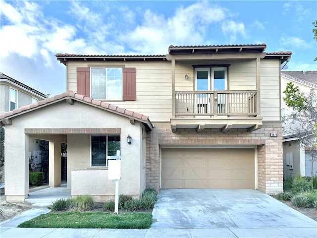 view of front of house with stucco siding, concrete driveway, a garage, a balcony, and a tiled roof