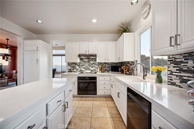 60125 Carrizo Rd, Mountain Center, CA 92561 - kitchen featuring under cabinet range hood, backsplash, black appliances, and a sink