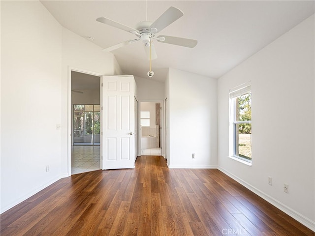 spare room featuring baseboards, wood-type flooring, ceiling fan, and vaulted ceiling