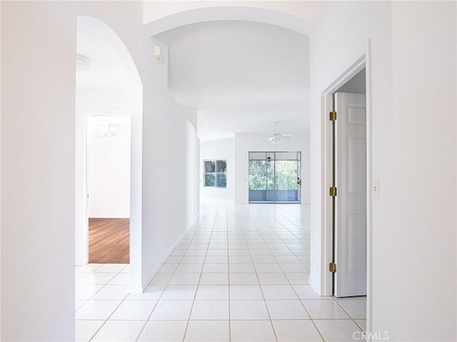 hall featuring baseboards and light tile patterned flooring