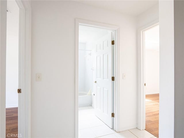 hall with baseboards and light wood-style flooring