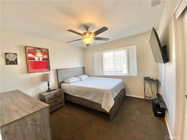 bedroom featuring visible vents, dark carpet, a ceiling fan, and baseboards