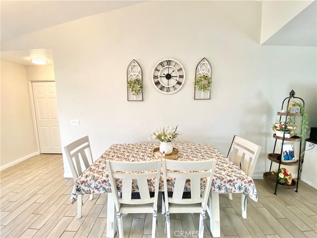 dining space featuring light wood-style flooring and baseboards