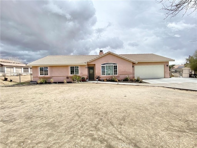 single story home with stucco siding, fence, a garage, a chimney, and a tiled roof