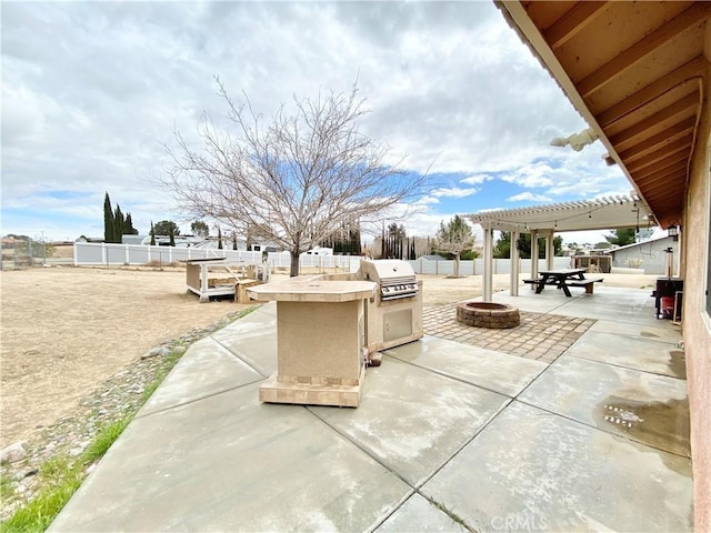 view of patio featuring area for grilling, a grill, a fenced backyard, and an outdoor fire pit