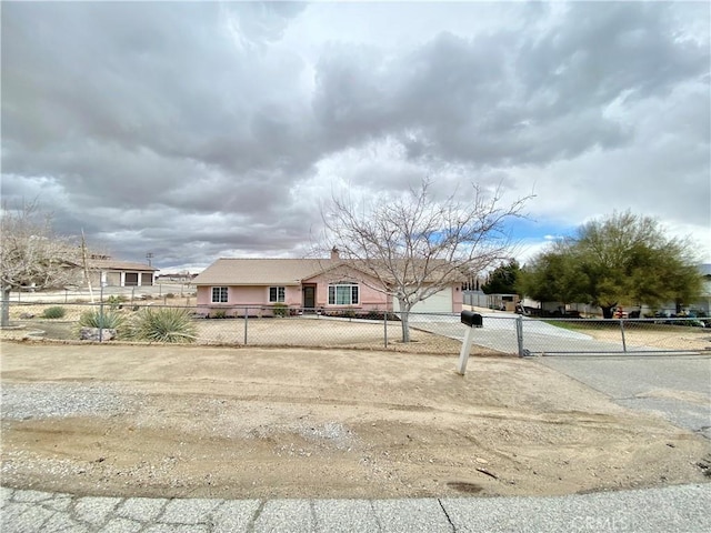 view of front facade with a fenced front yard, an attached garage, driveway, and stucco siding