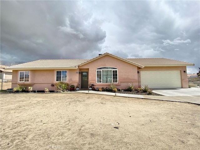 ranch-style house featuring a tiled roof, stucco siding, driveway, and a garage