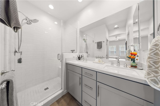 bathroom with a sink, recessed lighting, a stall shower, and double vanity