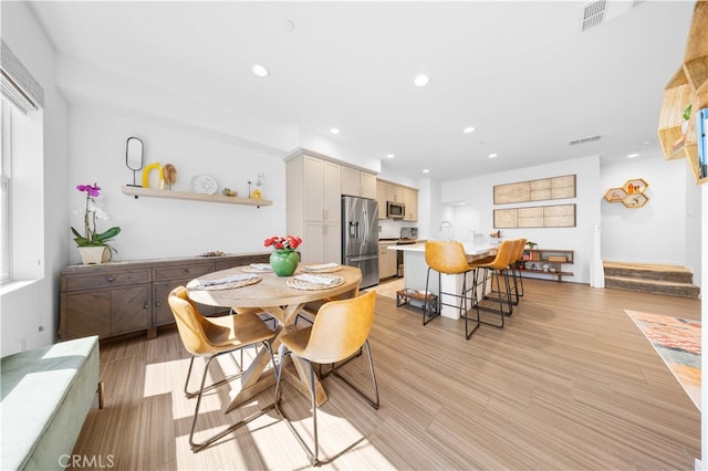 dining space with visible vents, recessed lighting, stairs, and light wood-style flooring