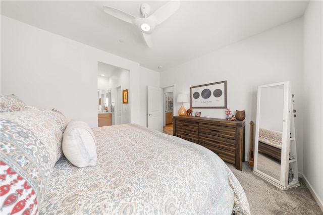 bedroom featuring light colored carpet, baseboards, connected bathroom, and a ceiling fan