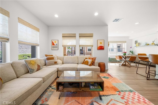 living area with recessed lighting, visible vents, and a healthy amount of sunlight