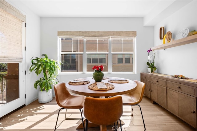 dining area with light wood-style flooring and baseboards