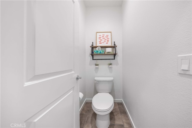 bathroom with tile patterned flooring, toilet, and baseboards