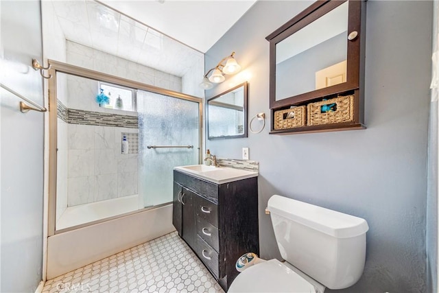 bathroom featuring toilet, vanity, and shower / bath combination with glass door