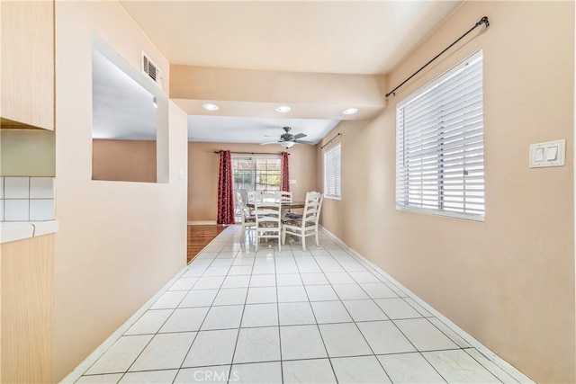 unfurnished dining area featuring light tile patterned floors, baseboards, visible vents, and ceiling fan