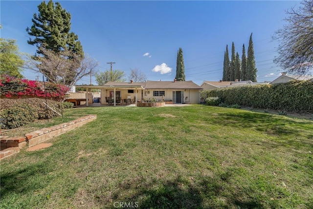 back of property with a yard and a patio area