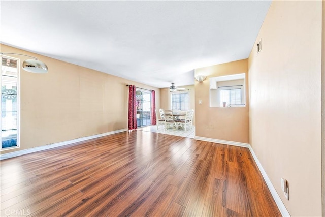 interior space with visible vents, a ceiling fan, baseboards, and wood finished floors