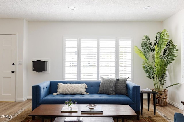 living area featuring plenty of natural light, wood finished floors, and a textured ceiling