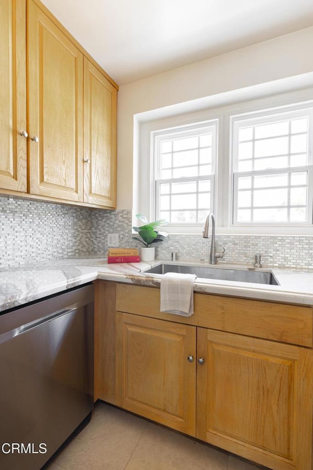 kitchen with dishwasher, light tile patterned floors, backsplash, and a sink