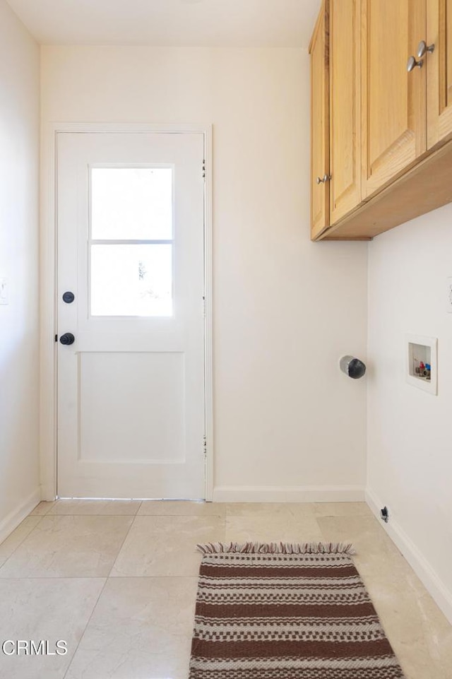 clothes washing area with light tile patterned floors, baseboards, cabinet space, and hookup for a washing machine