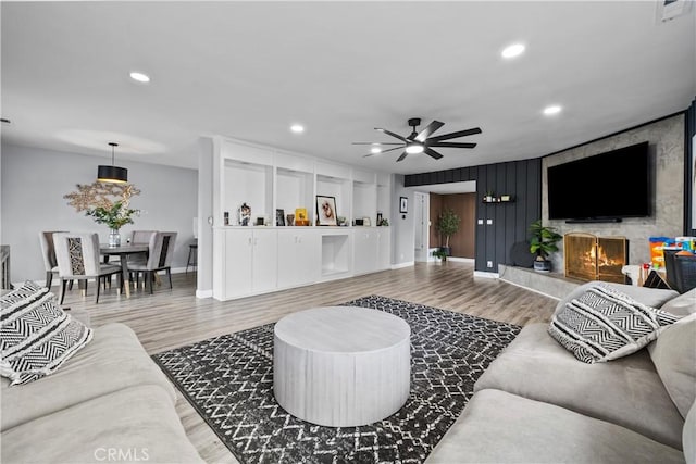 living room with recessed lighting, wood finished floors, and a tile fireplace