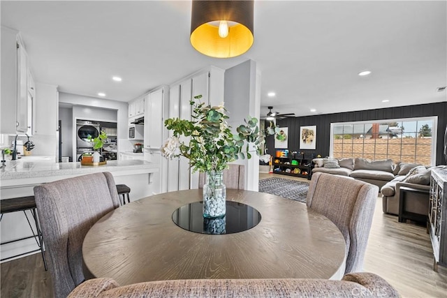 dining area with recessed lighting, wood finished floors, stacked washer / drying machine, and ceiling fan