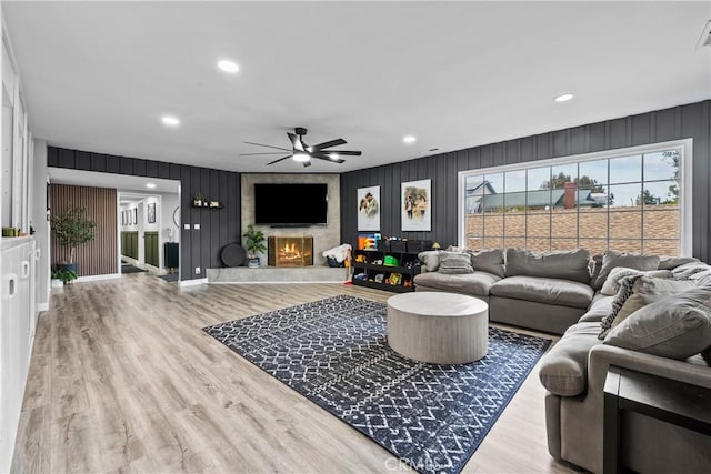 living room with a large fireplace, baseboards, recessed lighting, wood finished floors, and a ceiling fan