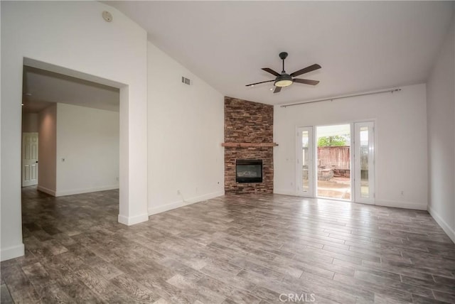 unfurnished living room featuring baseboards, ceiling fan, vaulted ceiling, a fireplace, and wood finished floors