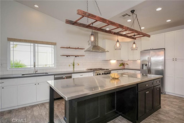 kitchen featuring backsplash, light wood-style floors, appliances with stainless steel finishes, and a sink