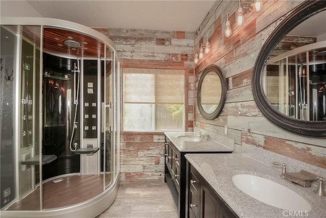 full bath featuring two vanities, wood walls, and a sink