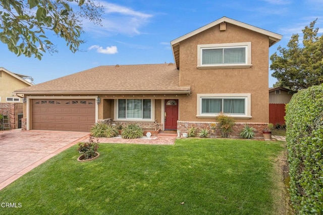 traditional-style house with a front yard, decorative driveway, fence, and stucco siding