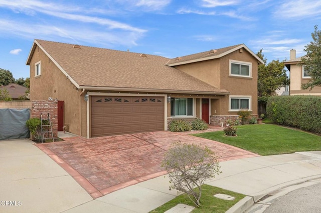 traditional-style house with stucco siding, decorative driveway, a front yard, and fence