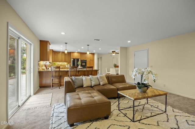 living room featuring visible vents, a ceiling fan, recessed lighting, baseboards, and light colored carpet