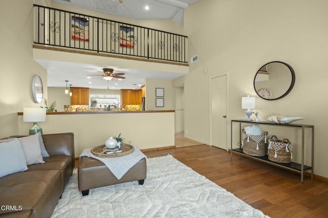 living room with visible vents, ceiling fan, recessed lighting, a towering ceiling, and wood finished floors