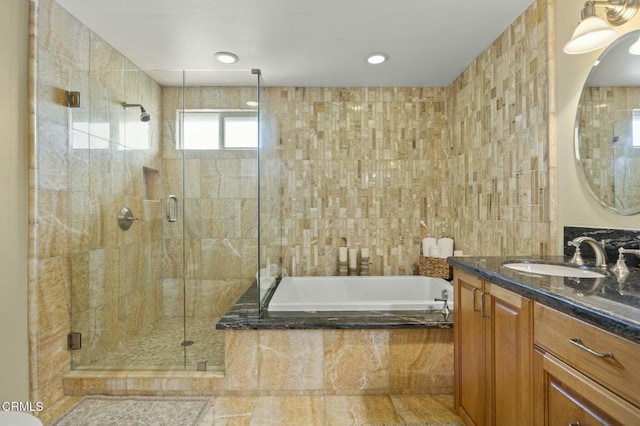 full bathroom featuring a bath, a shower stall, tile walls, and vanity