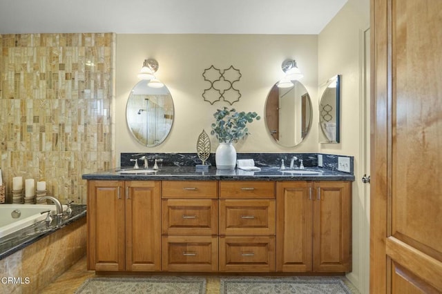 full bathroom with tiled bath, tile patterned flooring, double vanity, and a sink